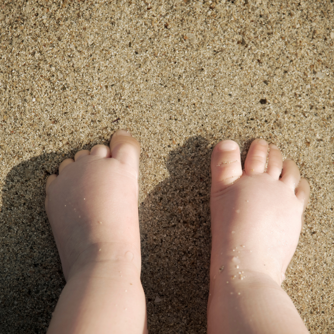 kleine sandige Babyfüße am Strand